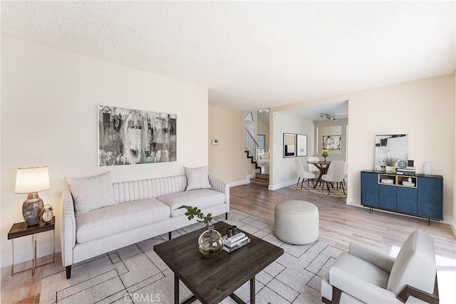 1076 N Ironwood Ave, Rialto, CA 92376 - living area featuring baseboards, a textured ceiling, stairway, and wood finished floors