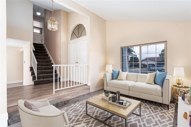 1076 N Ironwood Ave, Rialto, CA 92376 - living room featuring stairs, high vaulted ceiling, wood finished floors, and baseboards