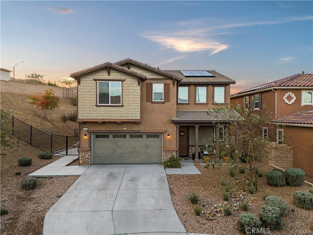 craftsman-style house with driveway, a gate, stucco siding, fence, and solar panels