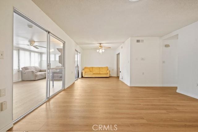 19324 Flowers Ct, Newhall, CA 91321 - unfurnished living room featuring a ceiling fan, light wood finished floors, and baseboards
