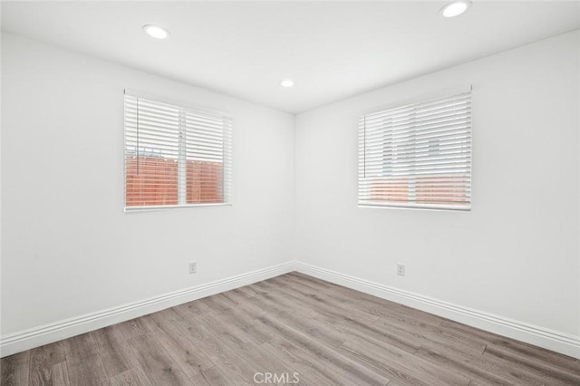 unfurnished room featuring recessed lighting, baseboards, and wood finished floors