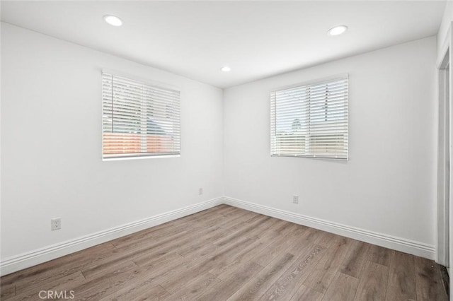 unfurnished room with recessed lighting, baseboards, and wood finished floors