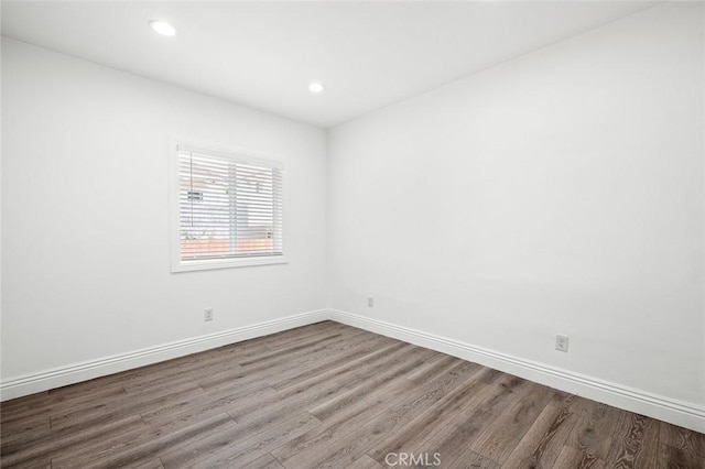 unfurnished room featuring recessed lighting, baseboards, and wood finished floors