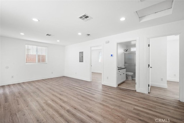 interior space featuring visible vents, electric panel, recessed lighting, attic access, and light wood-style floors