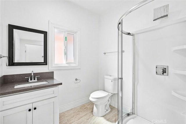 full bath with a stall shower, baseboards, toilet, and vanity