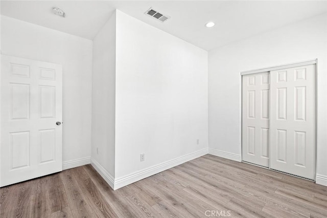 unfurnished bedroom with baseboards, visible vents, and wood finished floors