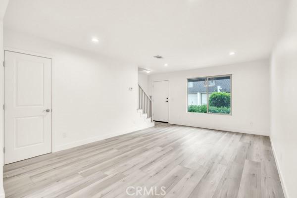 914 Fairview Ave Unit 15, Arcadia, CA 91007 - unfurnished living room with stairs, light wood-style floors, and recessed lighting