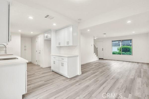 914 Fairview Ave Unit 15, Arcadia, CA 91007 - kitchen featuring light wood finished floors, white cabinets, open floor plan, light countertops, and recessed lighting