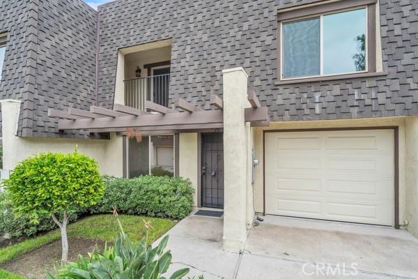 914 Fairview Ave Unit 15, Arcadia, CA 91007 - view of exterior entry with a balcony, stucco siding, an attached garage, and roof with shingles