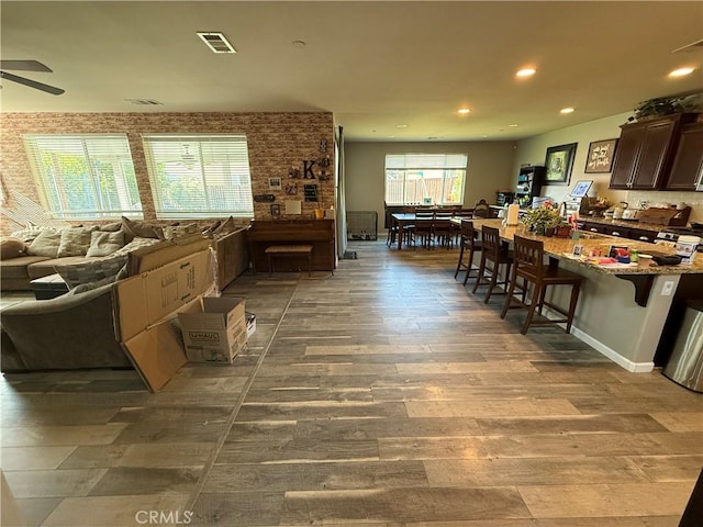 30130 Pine Needle Rd, Menifee, CA 92585 - kitchen featuring a ceiling fan, a kitchen bar, wood finished floors, and recessed lighting