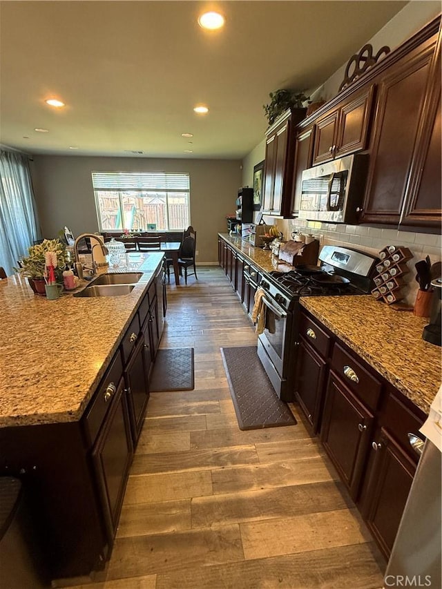 30130 Pine Needle Rd, Menifee, CA 92585 - kitchen with stainless steel appliances, a sink, wood finished floors, recessed lighting, and backsplash