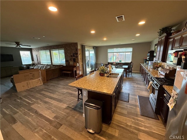 30130 Pine Needle Rd, Menifee, CA 92585 - kitchen with a sink, stainless steel appliances, dark wood finished floors, dark brown cabinetry, and recessed lighting