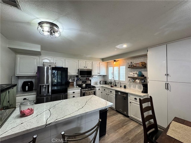 40451 Rome Beauty Way, Cherry Valley, CA 92223 - kitchen with stainless steel appliances, dark wood-style flooring, light stone counters, open shelves, and a textured ceiling