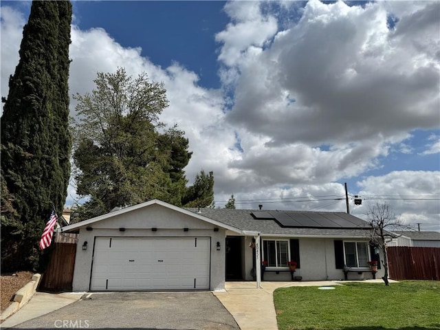 40451 Rome Beauty Way, Cherry Valley, CA 92223 - ranch-style home featuring a garage, driveway, stucco siding, roof mounted solar panels, and a shingled roof