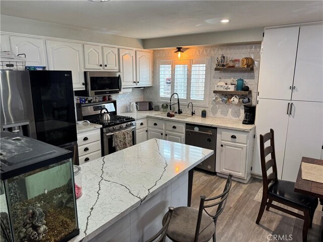 40451 Rome Beauty Way, Cherry Valley, CA 92223 - kitchen featuring stainless steel appliances, a sink, light stone counters, light wood finished floors, and white cabinets