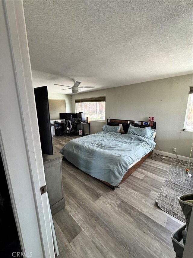 40451 Rome Beauty Way, Cherry Valley, CA 92223 - bedroom featuring a textured ceiling, a ceiling fan, wood finished floors, and baseboards