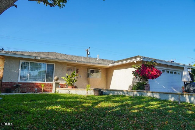 single story home with an attached garage, a front yard, and stucco siding