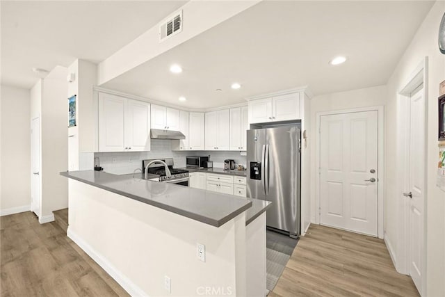 5402 Peck Rd, El Monte, CA 91732 - kitchen featuring stainless steel appliances, under cabinet range hood, a peninsula, white cabinetry, and light wood-style flooring