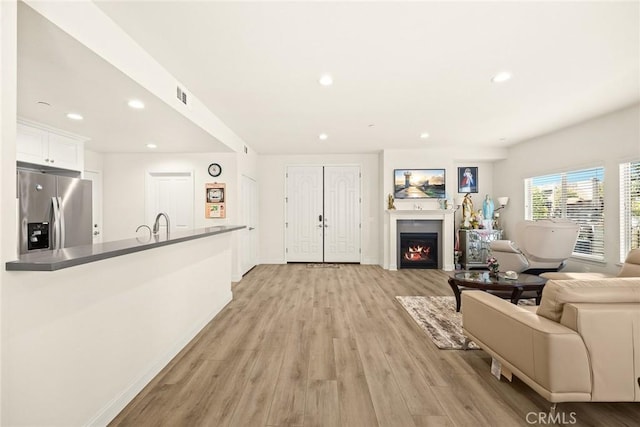 5402 Peck Rd, El Monte, CA 91732 - living area featuring light wood finished floors, a warm lit fireplace, and recessed lighting