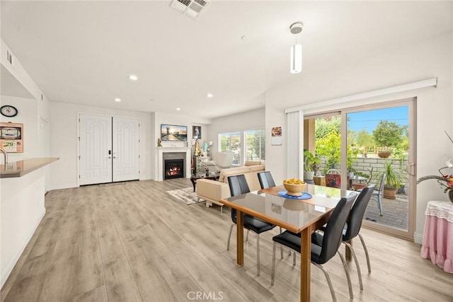 5402 Peck Rd, El Monte, CA 91732 - dining room with light wood finished floors, a lit fireplace, and recessed lighting