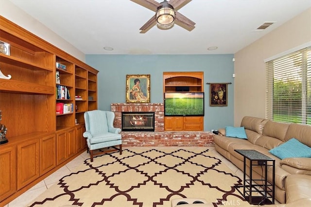 living area with ceiling fan, a fireplace, and light tile patterned flooring