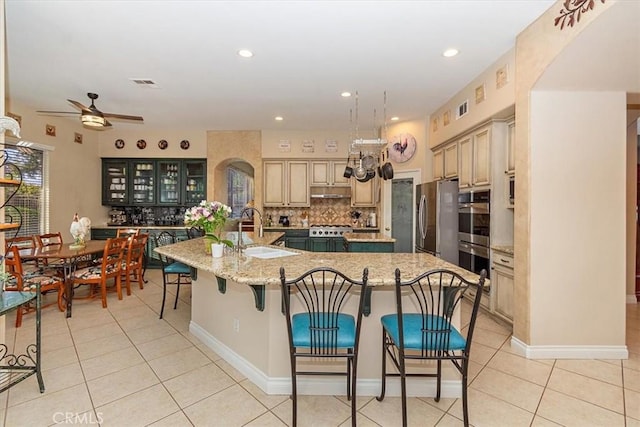 kitchen with a sink, a large island, backsplash, ceiling fan, and light tile patterned floors