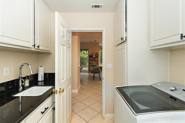 washroom with washer / clothes dryer, cabinet space, light tile patterned floors, and baseboards