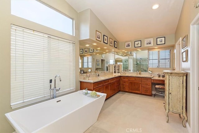 full bath with a freestanding tub, vaulted ceiling, vanity, and recessed lighting