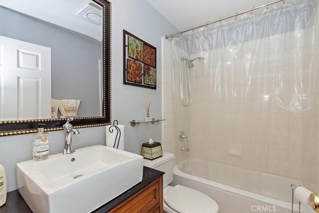 full bathroom featuring toilet, shower / bath combination with curtain, and vanity