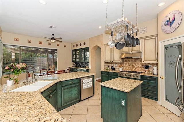 kitchen featuring green cabinetry, a sink, a ceiling fan, stainless steel appliances, and arched walkways
