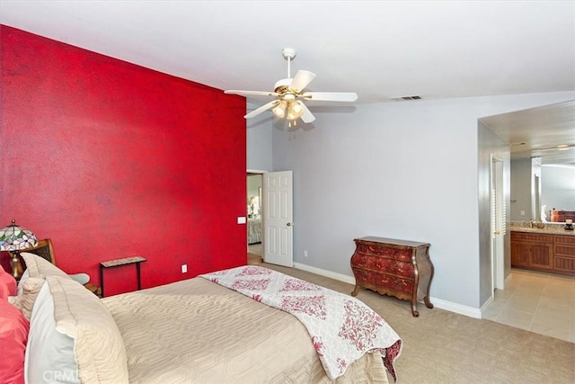 bedroom featuring baseboards, carpet, a sink, a ceiling fan, and connected bathroom