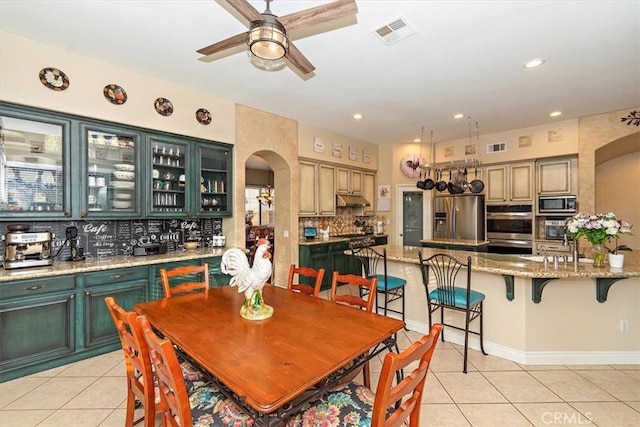 dining area with arched walkways, light tile patterned floors, ceiling fan, and recessed lighting