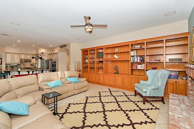 living area featuring light tile patterned flooring, a ceiling fan, arched walkways, and recessed lighting