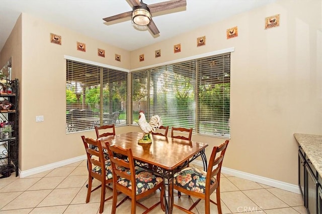 dining area featuring a ceiling fan, light tile patterned floors, and baseboards