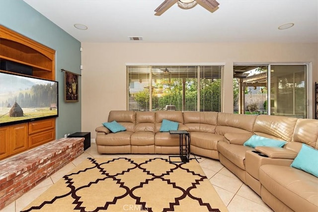 living area featuring light tile patterned floors, healthy amount of natural light, and a ceiling fan