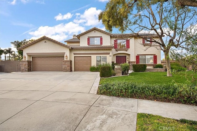 mediterranean / spanish-style house with stucco siding, concrete driveway, a front yard, and an attached garage