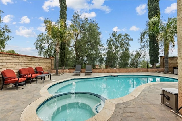 view of pool featuring a fenced backyard, a patio area, and a pool with connected hot tub