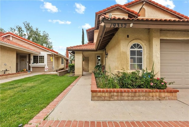 mediterranean / spanish house with a tile roof, a front yard, and stucco siding