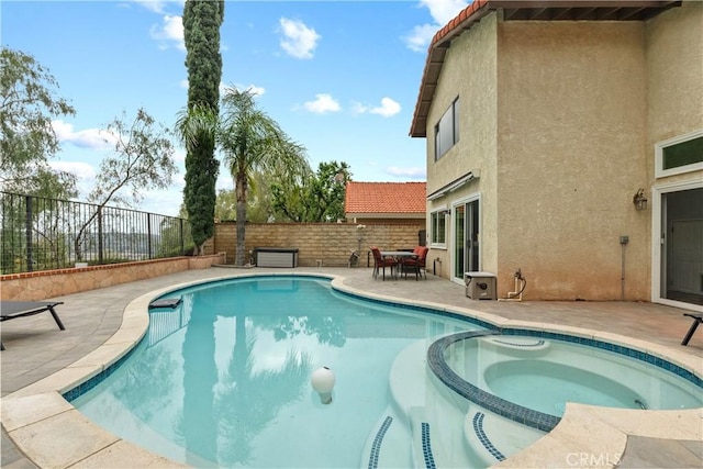 view of swimming pool with a pool with connected hot tub, a fenced backyard, and a patio