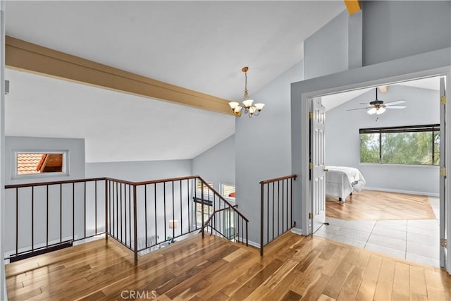 hallway featuring baseboards, a chandelier, an upstairs landing, lofted ceiling, and wood finished floors