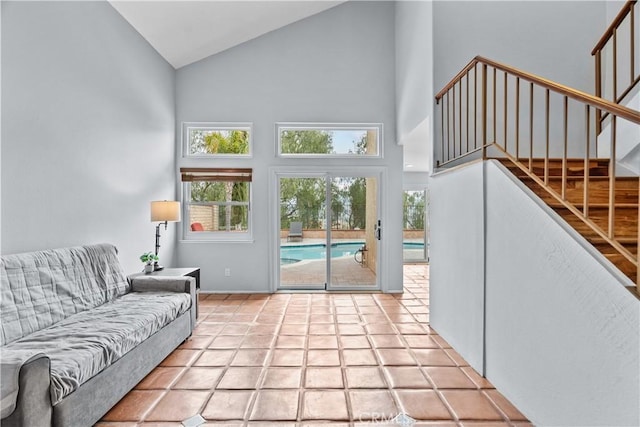 living room with baseboards, stairs, and high vaulted ceiling
