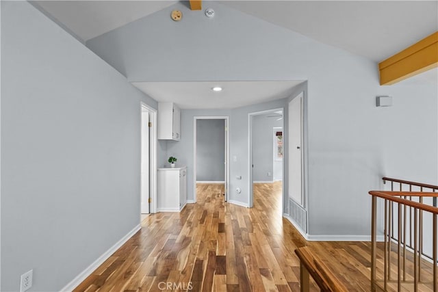 corridor with recessed lighting, light wood-type flooring, vaulted ceiling with beams, and baseboards