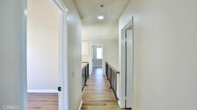 45299 Esmerado Ct, Temecula, CA 92592 - hall with light wood-style flooring, a textured ceiling, recessed lighting, and baseboards