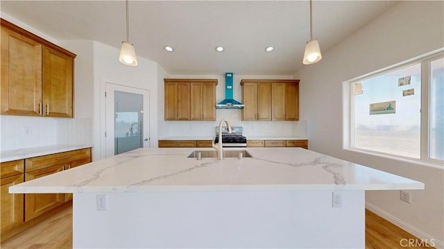 kitchen with brown cabinetry, wall chimney exhaust hood, and tasteful backsplash