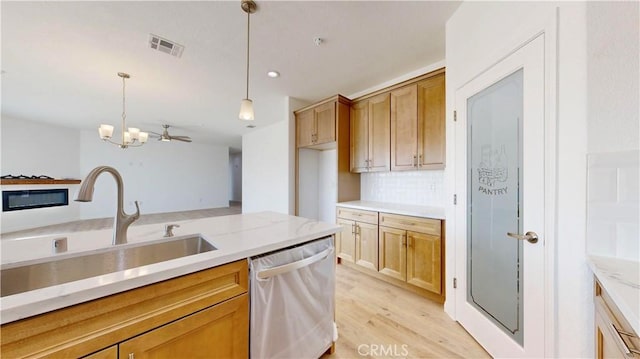 kitchen with a sink, visible vents, an inviting chandelier, dishwasher, and hanging light fixtures