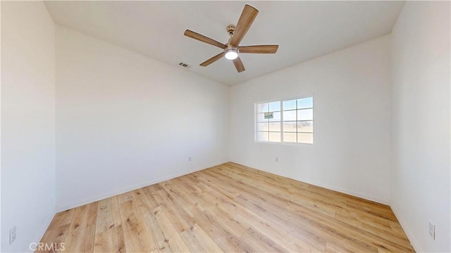 unfurnished room featuring baseboards, wood finished floors, visible vents, and ceiling fan
