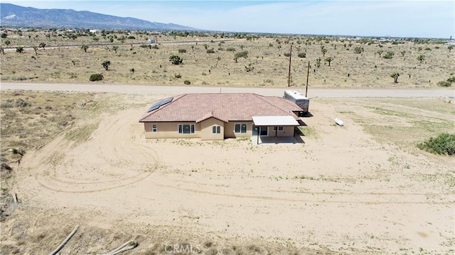 drone / aerial view with a rural view, view of desert, and a mountain view
