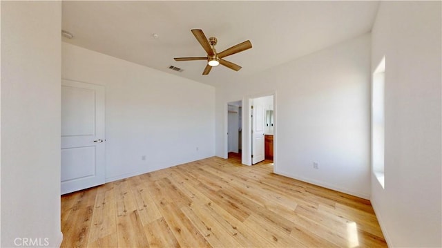unfurnished bedroom featuring light wood-type flooring, visible vents, ceiling fan, and ensuite bathroom