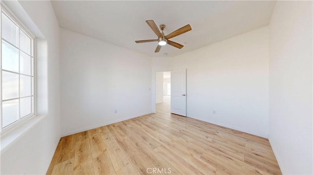 unfurnished room with baseboards, a ceiling fan, and light wood-style flooring