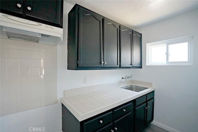 5101 Lindsey Ave, Pico Rivera, CA 90660 - kitchen featuring a sink, under cabinet range hood, and tile countertops